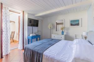 a white bedroom with a bed and a blue table at Suite Carducci Viareggio in Viareggio