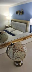 a bedroom with a bed with two mirrors and a globe at Suite Carducci Viareggio in Viareggio