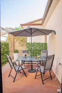 a table and chairs with an umbrella on a patio at Suite Carducci Viareggio in Viareggio
