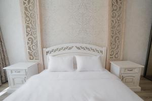 リヴィウにあるАпартаменти з 2-ма ізольованими спальнями і балконом в центрі Львоваの白いベッド(白い枕付)、ナイトスタンド