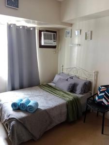 伊洛伊洛的住宿－AVIDA ATRIA T2- A, near SM city and smallville，一间卧室配有一张带2条蓝色毛巾的床