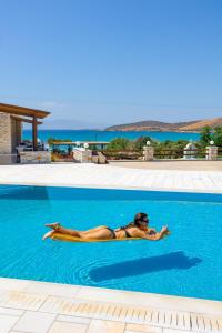 una donna sdraiata sul lato della piscina di Avgerinos Village ad Agiassos