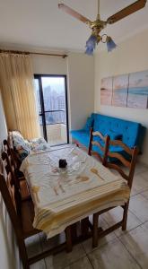 a bedroom with a bed and a table and chairs at Apartamento Praia Grande na Tupi Frente Mar in Praia Grande