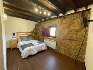 sypialnia z łóżkiem i kamienną ścianą w obiekcie Casa Rural Zirimiri en Herreros, Soria w mieście Herreros +32 zdjęcia