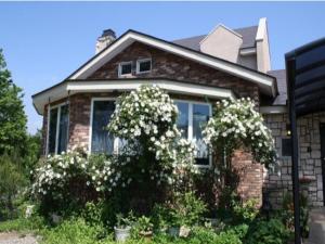 une maison en briques avec des fleurs blanches devant elle dans l'établissement Gasthof yell / Vacation STAY 79362, à Kuroiso