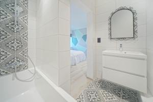 La salle de bains est pourvue d'une baignoire, d'un lavabo et d'un miroir. dans l'établissement Gîtes Chez Oncle Nicolas, à Soumagne