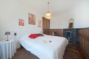 Un dormitorio con una gran cama blanca y una mesa en Gîtes Chez Oncle Nicolas, en Soumagne