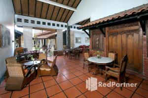 - un restaurant avec des tables et des chaises dans une salle dans l'établissement Rumah Palagan Yogyakarta RedPartner, à Ngaglik