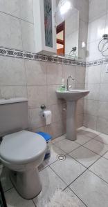 a bathroom with a toilet and a sink at Apartamento Praia Grande na Tupi Frente Mar in Praia Grande