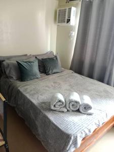 a bed with two towels on it with at AVIDA ATRIA T2- B, near S&R and SM city by Denice in Iloilo City