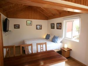 Schlafzimmer mit einem Bett, einem Tisch und einem Fenster in der Unterkunft Casa Isabel in Icod el Alto