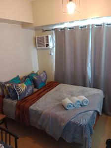 a bedroom with a bed with towels on it at AVIDA ATRIA T2- B, near S&R and SM city by Denice in Iloilo City