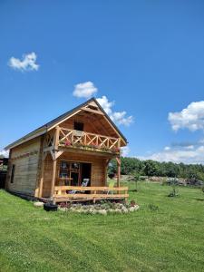 ein großes Holzhaus auf einem Grasfeld in der Unterkunft Gabel&Jurgen in Mirsk