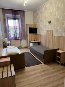 a bedroom with a bed and a desk in it at Korona Panzió in Mátészalka