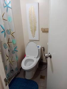 ein Bad mit einem WC und einem Duschvorhang in der Unterkunft AVIDA ATRIA T2- B, near S&R and SM city by Denice in Iloilo City