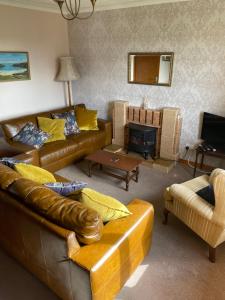 a living room with couches and a fire place at Taigh Na Casag in Lionel