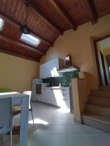 a kitchen with white cabinets and a table and chairs at CASINA DAMÍ in Canosa Sannita
