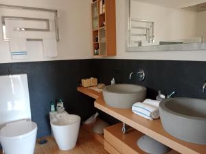 a bathroom with two sinks and a large mirror at Villa luce e relax in Saturnia