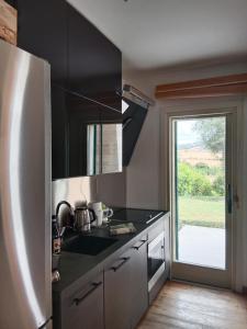 una cucina con banconi neri e frigorifero bianco di Villa luce e relax a Saturnia