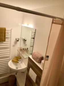 a white bathroom with a sink and a mirror at Gästehaus Langhals in Bad Segeberg