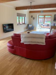 a red couch sitting in a living room at Captivating 4-Bed House in west Wales in Pencader