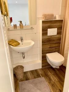 ein Bad mit einem Waschbecken und einem WC in der Unterkunft Gästehaus Langhals in Bad Segeberg