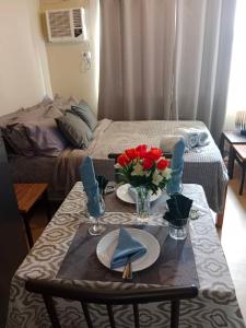 a room with a table with red roses on it at AVIDA ATRIA T2-C short walk mall,esplanade,wifi,netflix,kitchen,pool in Iloilo City