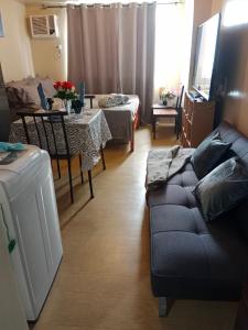 a living room with a couch and a table at AVIDA ATRIA T2-C short walk mall,esplanade,wifi,netflix,kitchen,pool in Iloilo City +53 photos