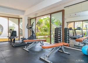 - une salle de sport avec des tapis de course et des équipements d'exercice dans un bâtiment dans l'établissement Le Petit Village Boutique Hotel & Spa, à Kampala