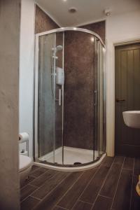 a bathroom with a shower with a toilet and a sink at Lizzie's Cottage in Drumaroad +17 photos