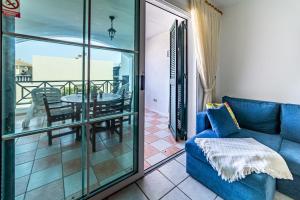 a living room with a blue couch and a balcony at Perla Marina en Rocas del Mar in Arona
