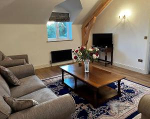 een woonkamer met een bank en een salontafel bij Byre - Farm Cottage on 9 acre Equestrian Small Holding in Salisbury