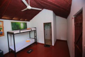Habitación con litera y ventilador de techo. en Sigiri Peace Hostel, en Sigiriya