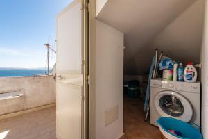une buanderie avec un lave-linge et une fenêtre dans l'établissement Casa Vacanze 21 Aprile - 1, à Calasetta