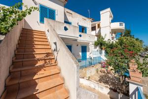 Un escalier mène à une maison avec des volets bleus. dans l'établissement Casa Vacanze 21 Aprile - 1, à Calasetta