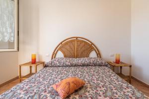 - une chambre avec un lit et 2 bougies sur 2 tables dans l'établissement Casa Vacanze 21 Aprile - 1, à Calasetta