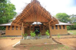 a small house with a straw roof at Sigiri Peace Hostel in Sigiriya
