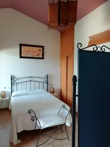 ein Schlafzimmer mit einem weißen Bett und einem Stuhl in der Unterkunft FUNDADORES, Isla Cristina in Isla Cristina