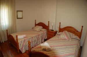 Apartamentos La Luz de Reinosa 2 في رينوسا: غرفة نوم بسريرين عليها مناشف