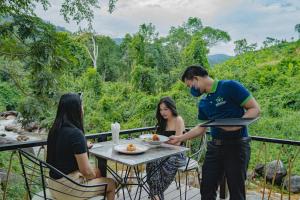 a group of people sitting at a table on a balcony at Green Valley Veal Pouch in Kampot
