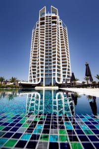a building with chairs in the water in front of a pool at Sky Tower in Limassol