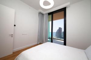 a bedroom with a white bed and a large window at Sky Tower in Limassol