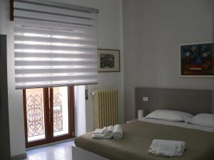 una camera con due letti e una finestra con persiane di Locanda Pezzolla ad Accettura