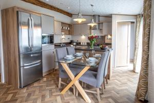 a kitchen with a dining table and a refrigerator at Stewarts Resort Lodge 8 in St. Andrews