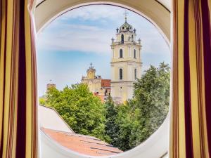 a view of a clock tower from a window at Stikliai Hotel - Relais & Châteaux in Vilnius