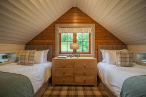 a attic bedroom with two beds and a window at High Oaks Grange - Lodges in Pickering
