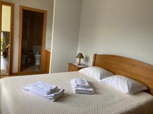 1 dormitorio con 1 cama con toallas en Casa da Lage - Piscina privada - Vistas rio, en Gerês