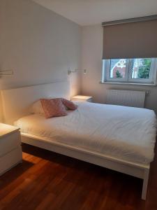 a white bed with two pillows on it in a bedroom at Precioso apartamento, aparcamiento gratis in Augustusburg