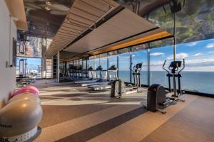 a gym with a row of treadmills and the ocean at Unique 1-BR w/Seaview Balcony and Onsen in Pattaya in Pattaya South