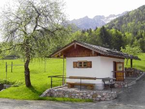 a small house in a field with a tree at Bräulerhof in Bayerisch Gmain